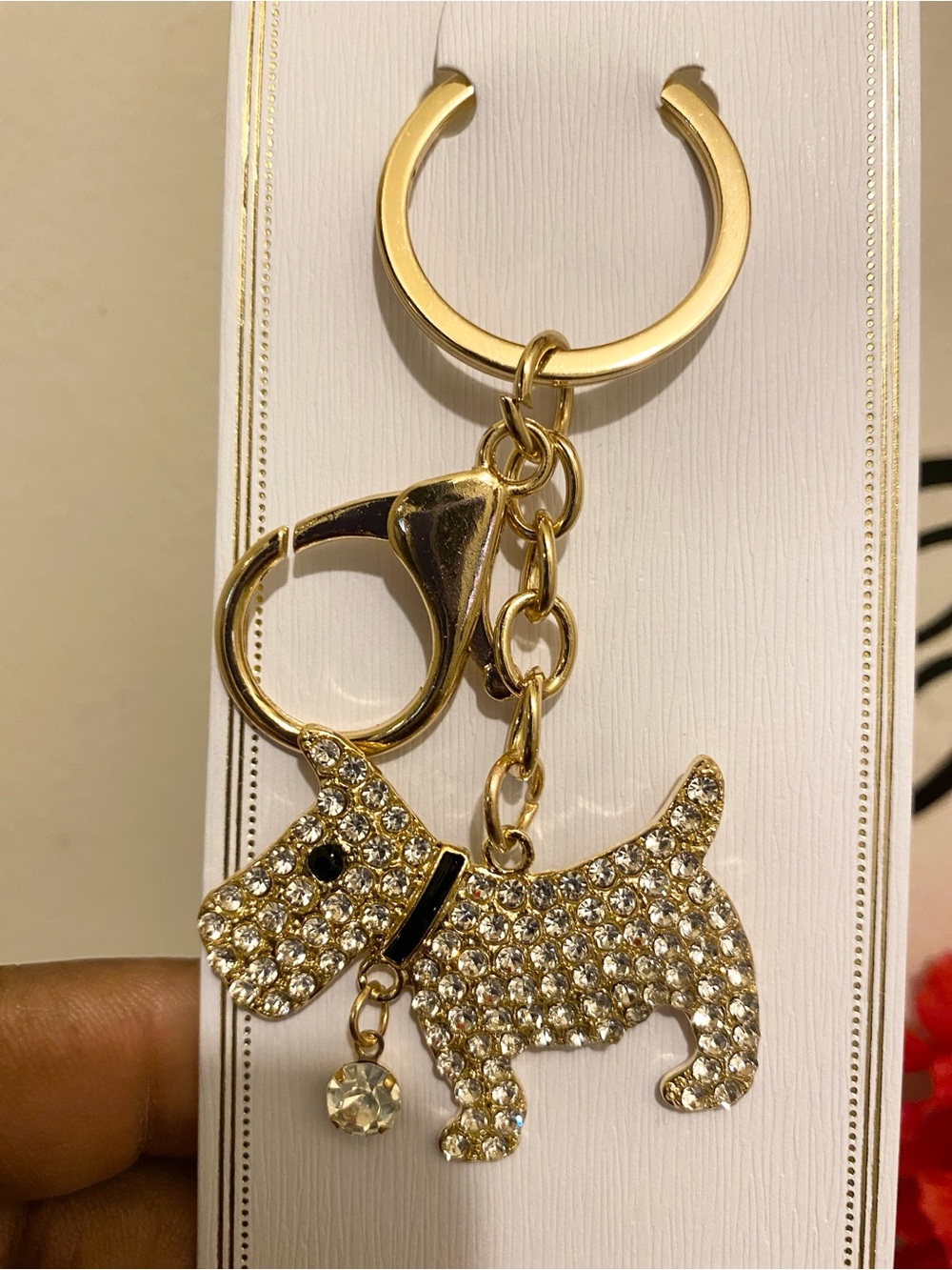 Gold-plated metal keychain of a Scottie dog adorned with white rhinestones.